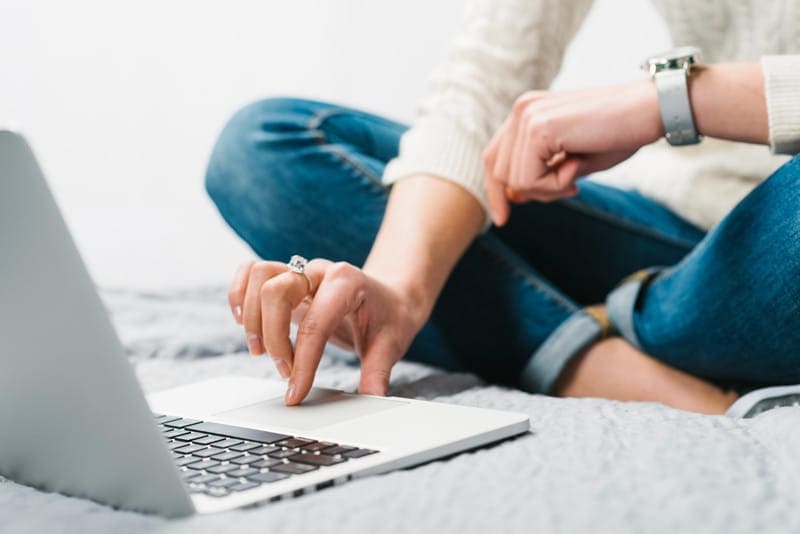 Femme utilisant un ordinateur portable, symbolisant la gestion des DNS d’un site web