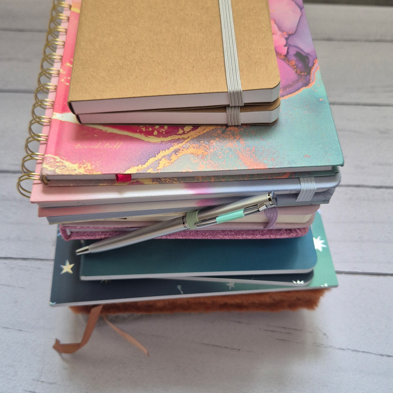 Pile de carnets et stylo utilisés pour les moments créatifs et de déconnexion en freelance.