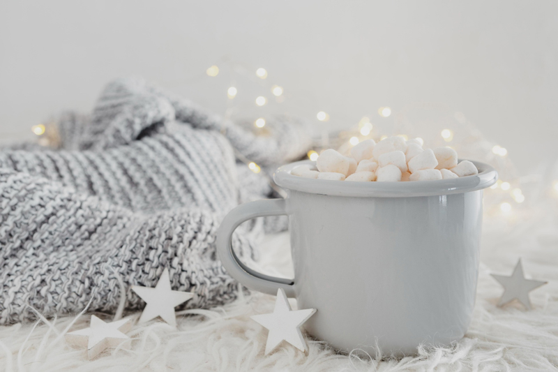 Tasse de chocolat chaud avec guimauves, plaid et ambiance cocooning après une surcharge mentale