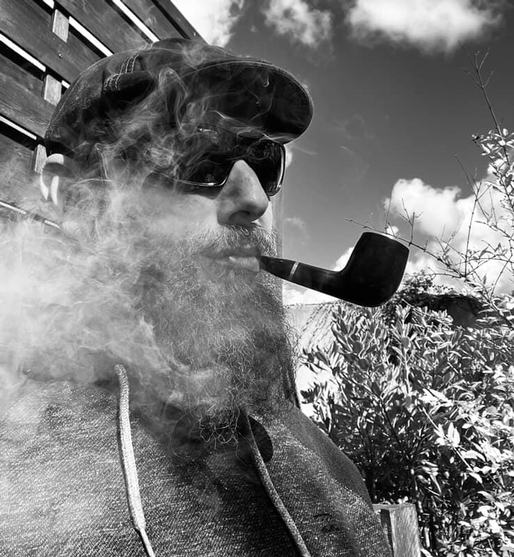 Portrait de Jérémie Morançon, auteur, en noir et blanc, fumant une pipe