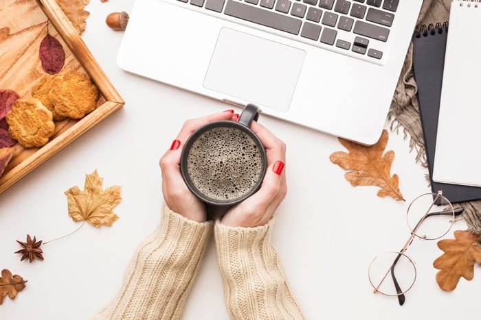 Ordinateur portable et tasse de café dans une ambiance automnale pour illustrer les idées d’articles saisonniers sur un blog lifestyle